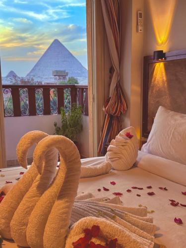 a room with a bed with a view of the pyramid at Flower Pyramids INN in Cairo