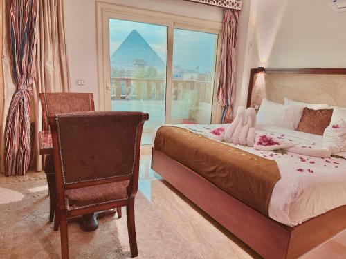 a bedroom with a bed and a chair and a window at Flower Pyramids INN in Cairo