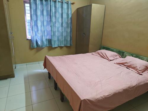 a bedroom with a bed with pink sheets and a window at Mahi's HomeStay in Nashik