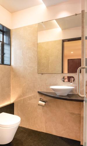 a bathroom with a sink and a toilet at Hotel Royal Palace Jalgaon in Jālgaon