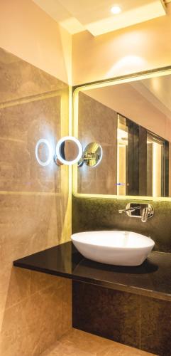 a bathroom with a sink and a mirror at Hotel Royal Palace Jalgaon in Jālgaon
