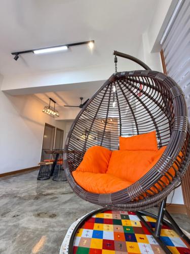 an orange couch in a hanging basket in a room at The Almost Touching the Stars Suite in Genting Highlands