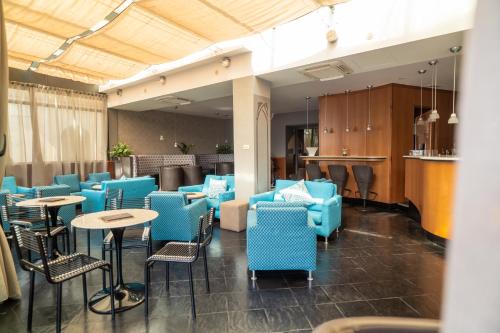 a restaurant with blue chairs and tables and a bar at Hotel Ligure in Alassio