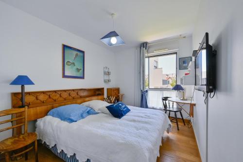 a bedroom with a bed and a tv and a desk at Le Rev - à 900m de la plage in La Baule