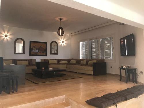 a living room with a couch and a table at Seaside Luxury Villa 4BR - Fnideq - Bahia Smir in Fnidek