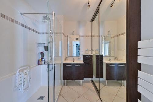 a bathroom with two sinks and a glass shower at Le Rev - à 900m de la plage in La Baule