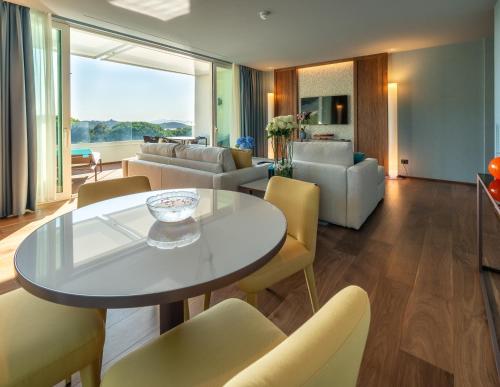 a living room with a table and chairs at Gallia Palace Hotel - Relais & Châteaux in Punta Ala