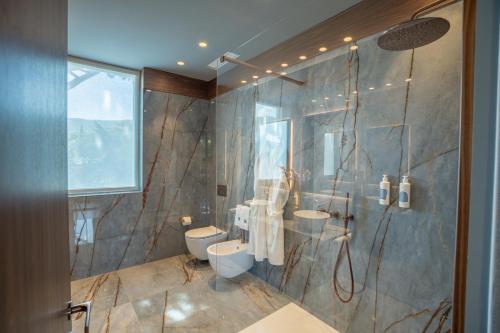 a bathroom with two sinks and two toilets at Gallia Palace Hotel - Relais & Châteaux in Punta Ala