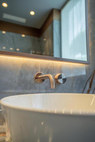 a bathroom with a white sink and a mirror at Gallia Palace Hotel - Relais & Châteaux in Punta Ala