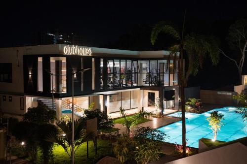 a large building with a swimming pool at night at Milestone Suites by Robinson Properties in Trivandrum