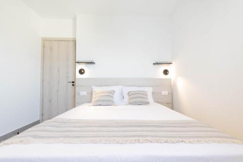 a bedroom with a white bed with two pillows at Napa Heights in Ayia Napa