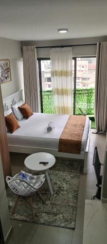 a bedroom with a large bed and a table at Modern Cozy Studio in Nairobi