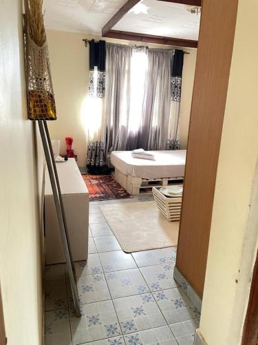 a room with a bedroom with a bed and a window at cozy home close to airport in Nairobi