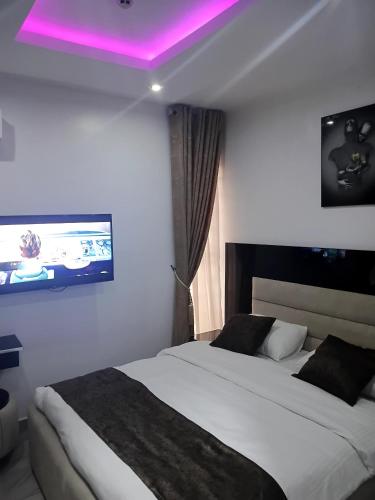 a bedroom with two beds and a tv on the wall at Grand Churchill Luxury Hotel in Orimedu