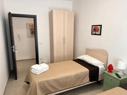 a small bedroom with a bed and a mirror at Casa Del Grillo Parlante in Aragona