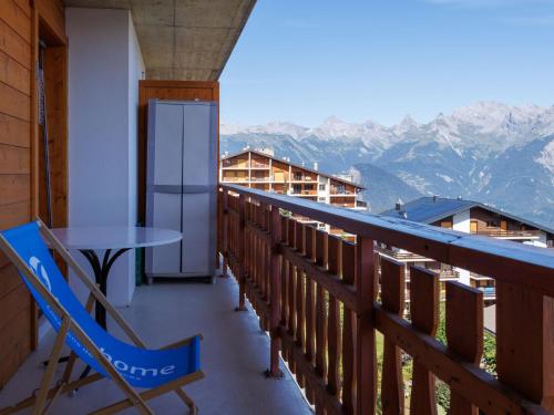 a balcony with a table and chairs and mountains at Apartment Grand Panorama A11 by Interhome in Nendaz