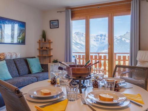 a living room with a table and a couch at Apartment Grand Panorama A11 by Interhome in Nendaz
