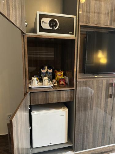 a small cabinet with a microwave and a tv at The Belmorris in Multan