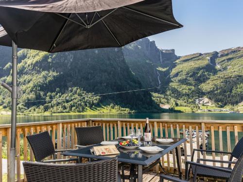una mesa y sillas en una terraza con sombrilla en Holiday Home Indresfjord by Interhome, en Åse