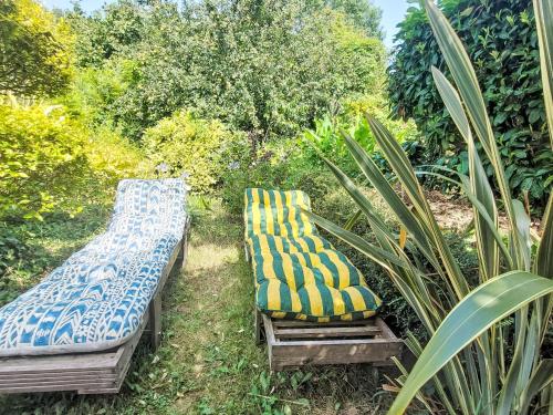 dos bancos sentados en el césped en un jardín en Holiday Home L'Oté rouge by Interhome, en Plérin