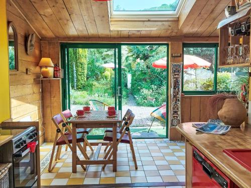 une cuisine avec une table et des chaises dans une cuisine dans l'établissement Holiday Home L'Oté rouge by Interhome, à Plérin