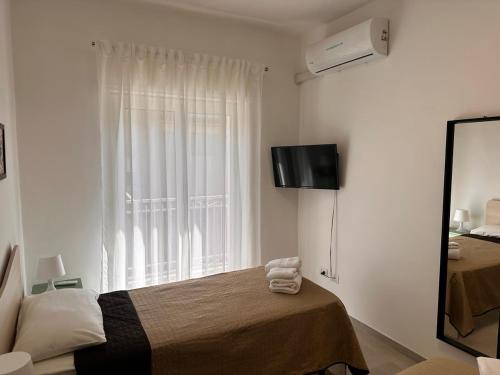 a bedroom with a bed and a mirror and a window at Casa Del Grillo Parlante in Aragona