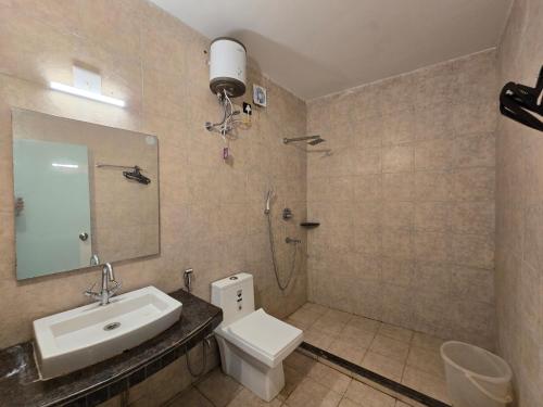a bathroom with a sink and a toilet and a mirror at Ricardo Beach Resort in Mandarmoni