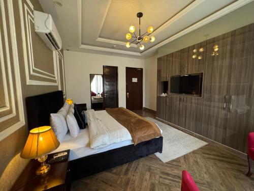 a bedroom with a large bed and a television at The Belmorris in Multan