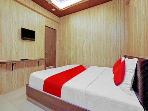 TurambheHotel Yatri Inn Vashi Navi Mumbai的卧室里有一张床和一台电视机