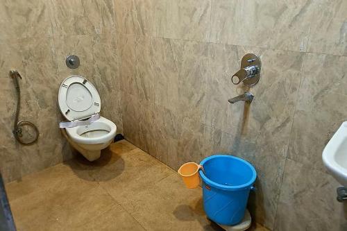 a bathroom with a toilet and a sink and a bucket at Fortune Heights in Hyderabad