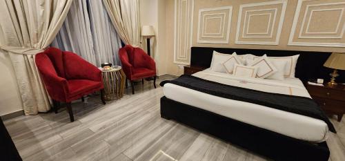 a bedroom with a large bed and red chairs at The Belmorris in Multan