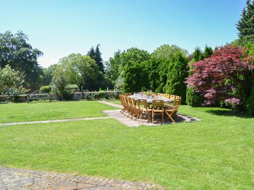 a table and chairs in the grass in a yard at The Dower House in Stowbridge