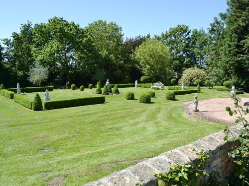 a garden with hedges and a stone wall at The Dower House in Stowbridge