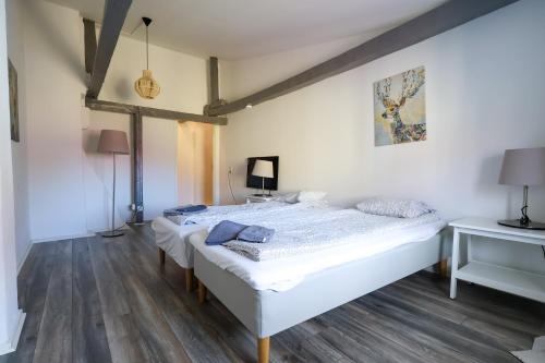 two beds in a room with wooden floors at Worker & families Dream Apartment in the heart of Gothenburg in Gothenburg