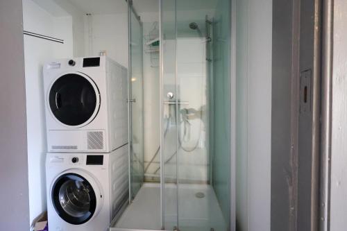 a washer and dryer in a bathroom with a shower at Worker & families Dream Apartment in the heart of Gothenburg in Gothenburg