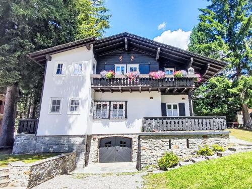 a house with a balcony with flowers on it at Chalet Chalet Franca by Interhome in Madesimo