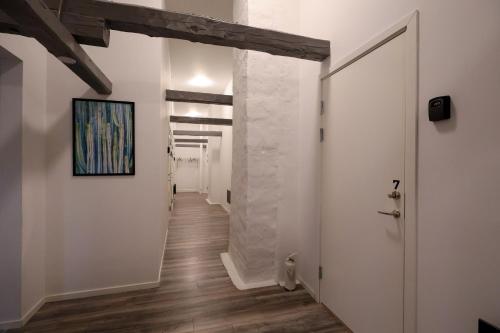 a hallway with white walls and a painting on the wall at Worker & families Dream Apartment in the heart of Gothenburg in Gothenburg