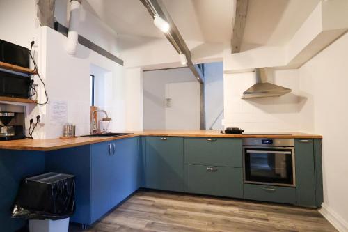 a kitchen with blue cabinets and a counter top at Worker & families Dream Apartment in the heart of Gothenburg in Gothenburg
