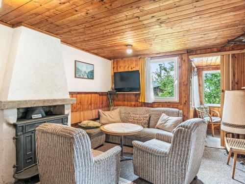 a living room with a couch and chairs and a fireplace at Chalet Vesec by Interhome in Vesec
