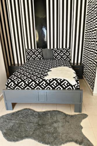 1 cama con edredón blanco y negro y alfombra en Charming Loft in Yoff Layene, en Dakar