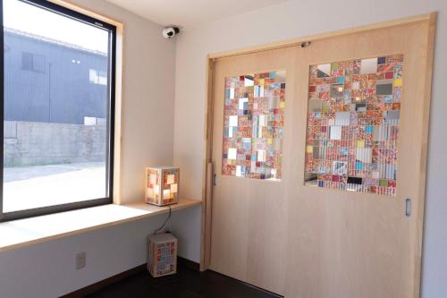 a room with a door with a collage on it at B&B Mikawa 6 - Loft Rooms in Hakusan