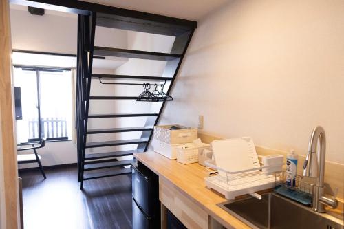a kitchen with a spiral staircase in a room at B&B Mikawa 6 - Loft Rooms in Hakusan