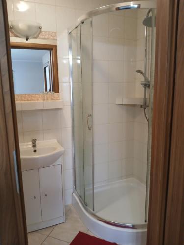 a bathroom with a shower and a sink at Pensjonat Oleńka in Ustka