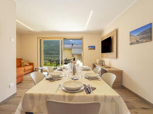 a dining room with a long table and white chairs at Holiday Home Guarnelle House 2 by Interhome in Bianzone