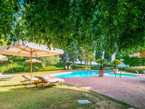 a swimming pool with chairs and an umbrella and a swimming pool at Holiday Home Villa Silvana by Interhome in Marcialla