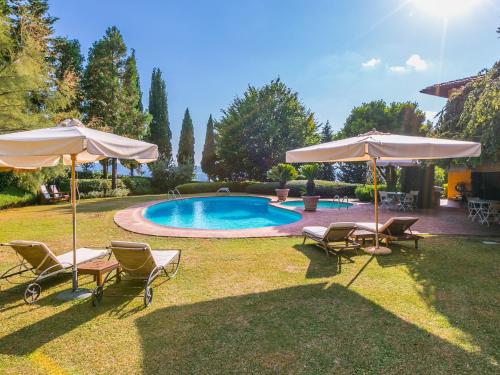 a yard with chairs and umbrellas and a pool at Holiday Home Villa Silvana by Interhome in Marcialla