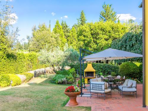 a patio with a table and chairs and an umbrella at Holiday Home Villa Silvana by Interhome in Marcialla