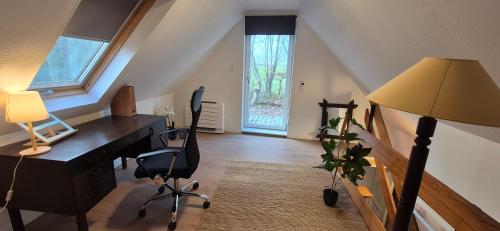 an attic office with a desk and a lamp at Gerringevej Guesthouse in Rødby