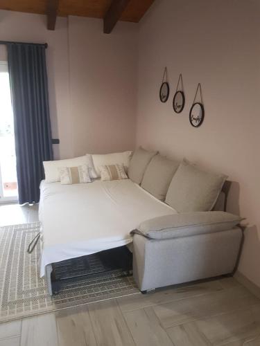 a white bed and a couch in a room at Endrit Accommodation in Vorë