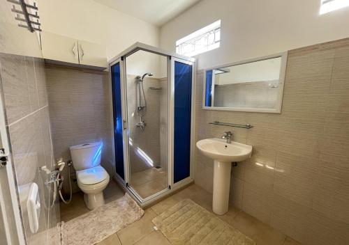 a bathroom with a toilet and a shower and a sink at Beach Walk Apartment with Private Garden & Wifi in Grand-Baie